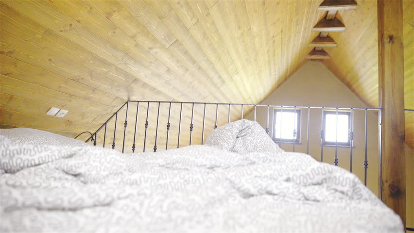 Woman tidy-up bedroom bed inside big retro house 4K. Camera on gimbal stabilizer sliding next to bed with attractive female person housekeeping with tidying up bed.