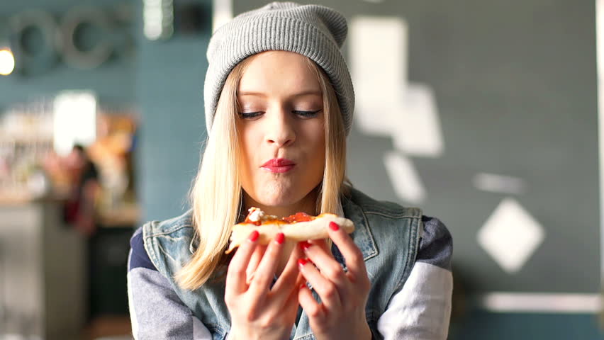 Hipster girl eating pizza in the restaurant and enjoying this
 | Shutterstock HD Video #19320940
