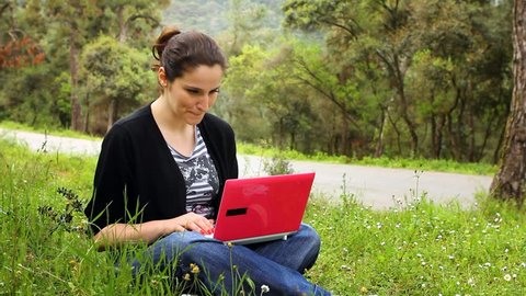 beautiful girl using computer in countryside, phaeton passing behind