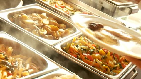 Restaurant guests select food from a buffet