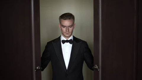 Scary man in a tuxedo and bow tie opens the door. Intro
