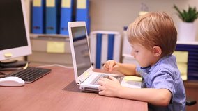 Cute little boy working on the laptop, typing something on computer, modern education in the elementary school, study with pleasure. Full HD Video 1920x1080