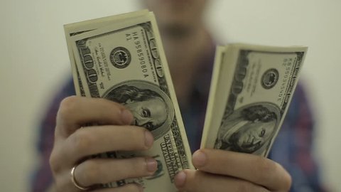 View of a man Counting Many American 100 bills, Man not happy about not having enough money.Slowmotion