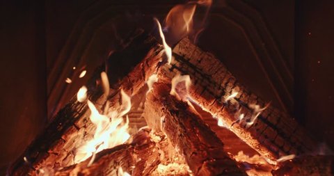 Close Up of Wood Burning in a Fireplace. 4K DCi SLOW MOTION 120 fps. Warm cozy fire in a hearth or fire pit. Calm Nature loopable Background. Autumn and Winter holidays. Chalet or Cabin comfort. 