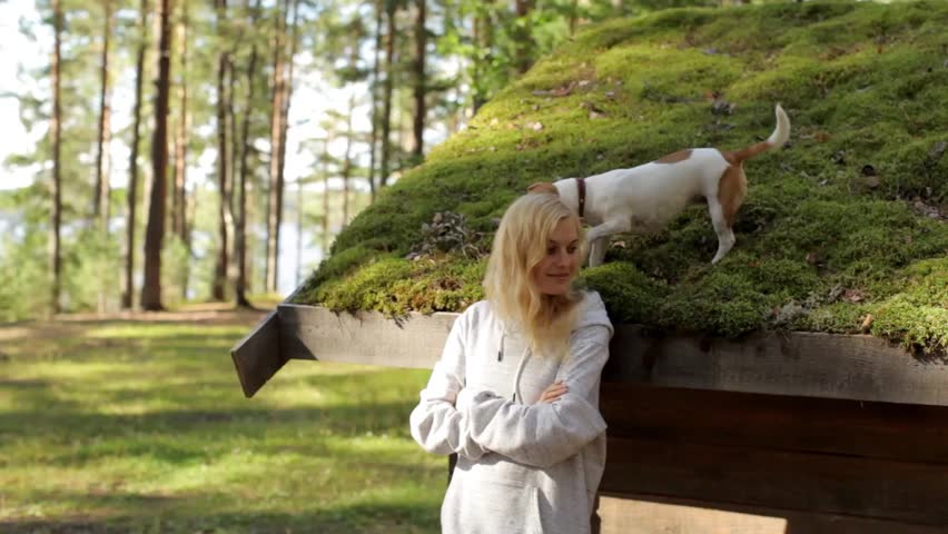 Girl Standing Next to the House With the Dog on the Roof