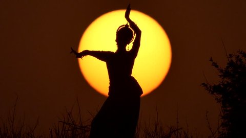 Silhouette girl oriental dancer a dance on sunset