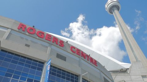 Toronto, Canada - CIRCA: August, 2016: Pan up of exterior of front of Rogers Centre stadium and the CN Tower in Toronto Canada