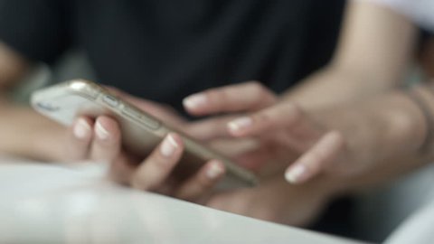 Close up hands of young woman showing something on phone. Close up of two people using smartphone.