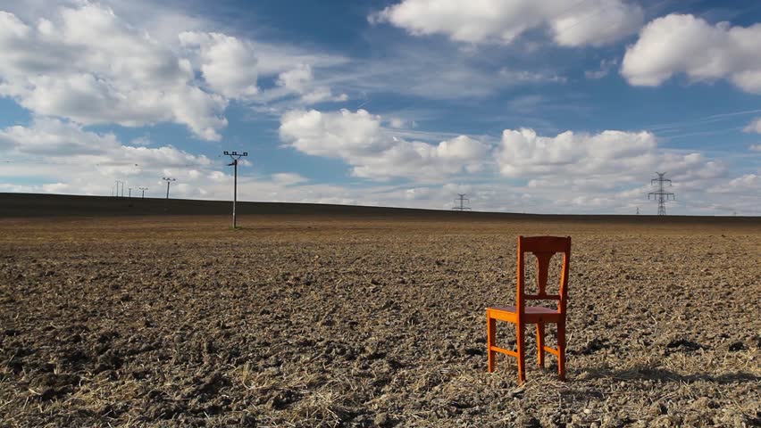Old wooden chair on the empty field after harvest