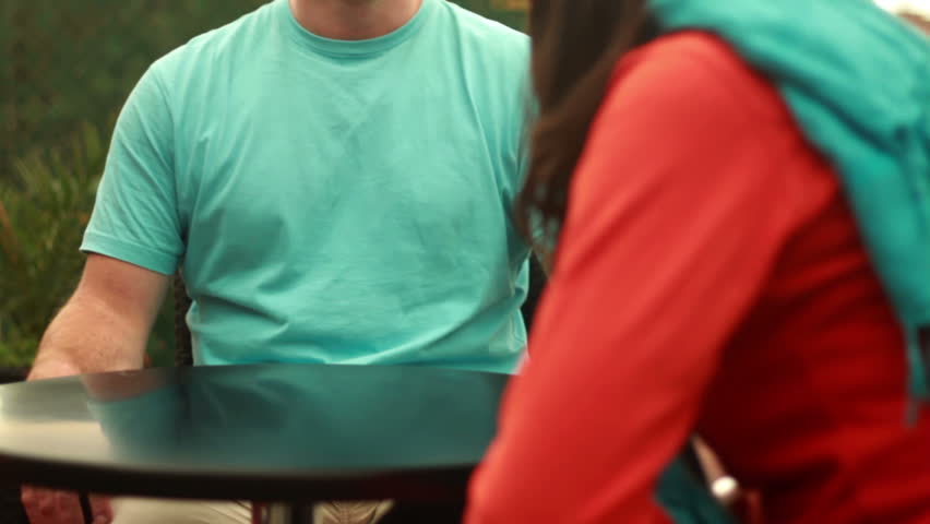 Young happy couple in cafe by city street, camera stabilizer shot 