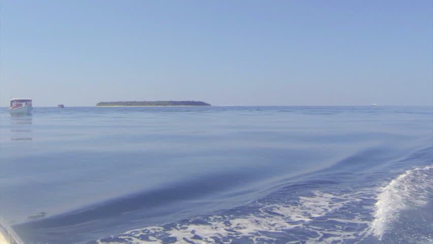 Cruising past a boat on calm water with an island in the background