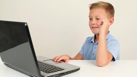 Kid using laptop, talking happily.