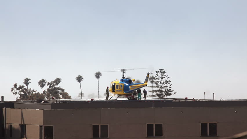 Patient being taken off rescue helicopter on the rooftop of a hospital. No