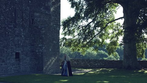 4k Medieval Shot of Queen Walking between Castle and Tree Stock Video