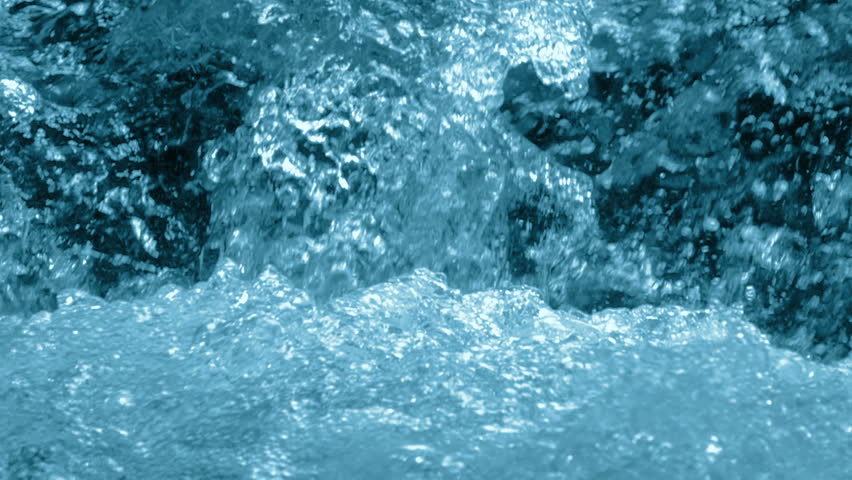 Water rages in the flow of the waterfall. Close-up. Slow motion