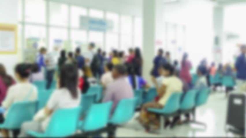 Blurred image of unidentified people and patient in hospital waiting medicine or doctor time-lapse.