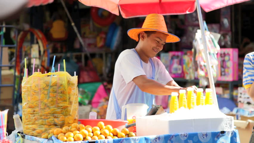 BANGKOK - JANUARY 21, 2012: A man sells fresh orange juice in the streets of