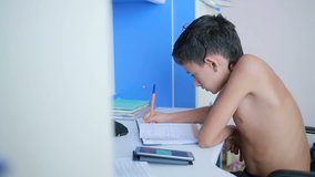 Teenage boy doing homework using a cell phone. natural video
