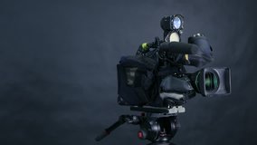 Professional digital video camera, camcoder isolated on black background in tv srudio.