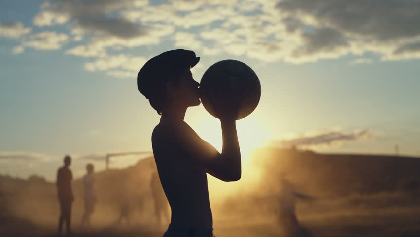 Child in hat kissing ball outside
