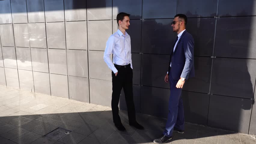 Two Entrepreneurs Guys in Suits Men Male Gender Talk and Discuss Issues. the Concept of Business Negotiation, Problem Solving, Working. Business Team Standing Near Center Office