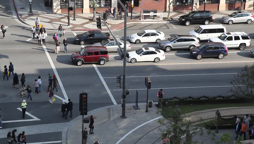 Unidentified people cross the street on the way to the the shopping mall for Christmas sale on December 18, 2011 in Los Angeles, California
