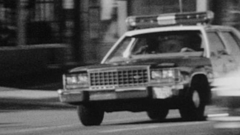 Los Angeles, California, USA - October 12, 1988:  Vintage super 8 black and white film of LAPD police car driving by.