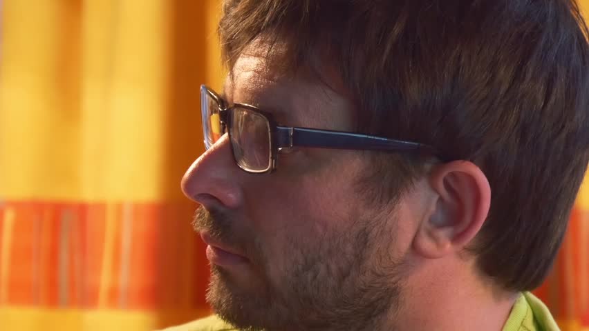 Portrait of serious man thinking or watching TV at home