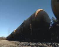 Freight train carrying tanks on rails. 