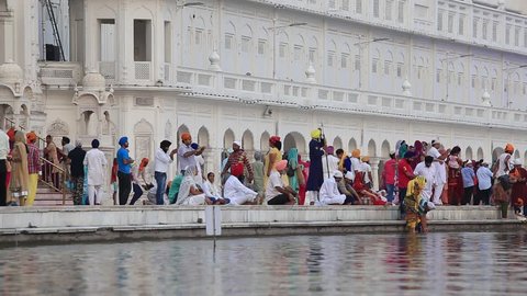 AMRITSAR, INDIA - SEPTEMBER 27, 2014: Unidentified Sikhs and indian people visiting the Golden Temple in Amritsar, Punjab, India. Sikh pilgrims travel from all over India to pray at this holy site.