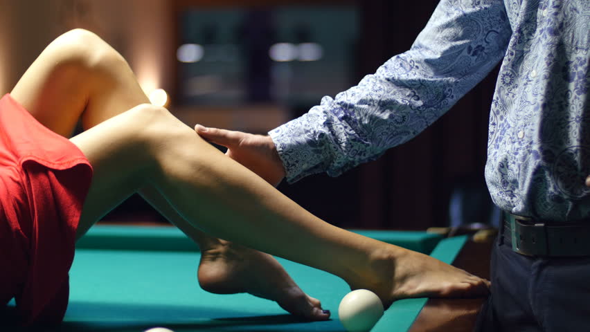 man gently stroked the girl her legs - on a billiard table