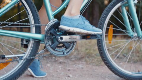Young beautiful female riding bike - detailed pedals and wheels