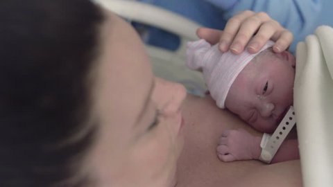 Newborn Baby Girl Laying on Mothers Chest After Delivery in Hospital