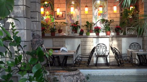 design and interior with the warm light and atmosphere with a fountain, tables in a cozy restaurant in the city