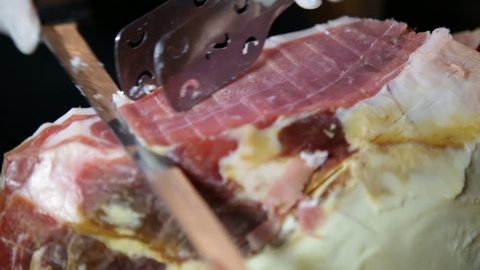 Waiter is Slicing some Slices of Ham in an Italian Restaurant during a wedding reception
