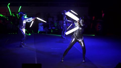 MOSCOW, RUSSIA - JANUARY 30, 2016: Final of Moscow stage of National Cup of "Robot wars-2016" at VDNH. A few people perform on arena in darkness in strange alien costumes and with lightsabers