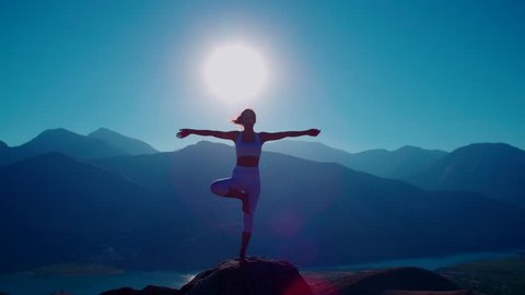 4K yoga in the mountains,the sunrise, a beautiful girl dressed in white ,pulls his hands to the sun