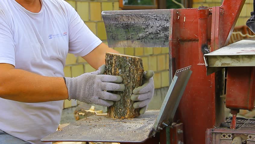Man operating wood cleaving machine