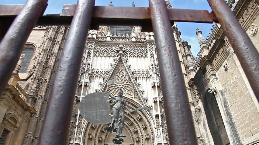 Gate of Royal Chapel of Granada, Andalucia, Spain. With close up on a statue in time lapse.
