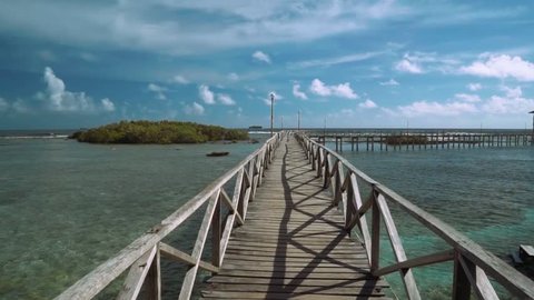 Moving forward on boardwalk in ocean, small island in front - on Siargao Island, Philippines
