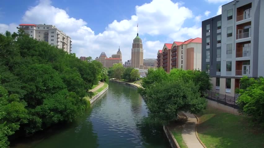 Aerial view of San Antonio riverwalk by skyline under sunny blue sky