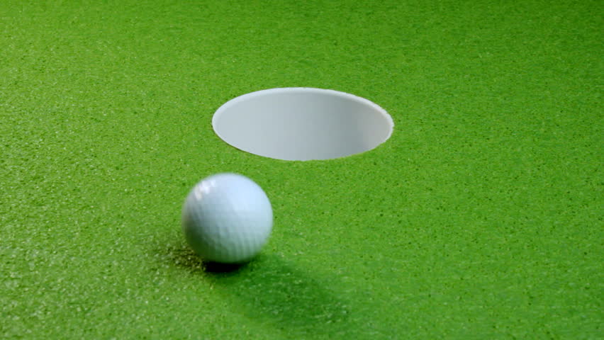 A golf ball misses the cup, multiple shots