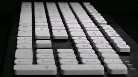 Ungraded: Hands on Keyboard / Typing on Computer / Keyboard Keys. User types a text using english keyboard against black background. (av27583u)