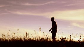 Happy child rushes into hands of father. Family hugs over sunset sky background. Silhouettes of anonymous boy and man outside in summer or autumn landscape. Video portrait of dad and son. Ukraine