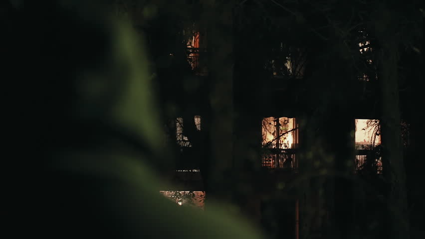 Hooded stalker stalking apartment from a distance at night,rack focus.A hooded ominous figure stalking a residential building at night Royalty-Free Stock Footage #19537489