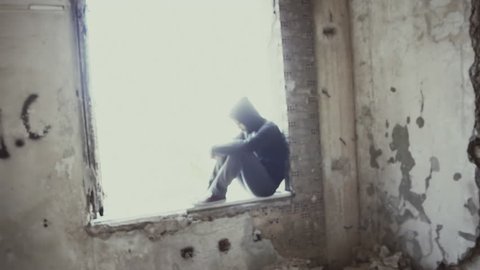 Hooded young man inside destroyed abandoned building,slow motion,dramatic.Young man facing social issues, inside a big wrecked empty building in 100fps slow motion.Camera gimbal motion.