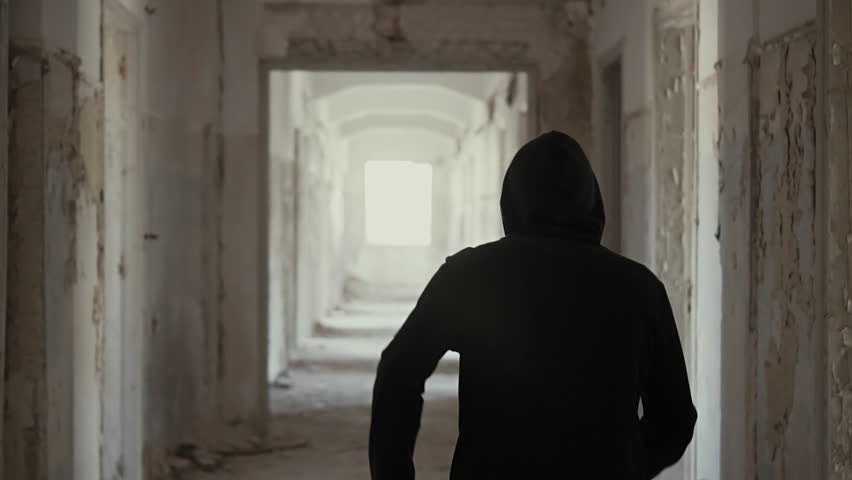 Hooded young man wondering inside destroyed abandoned building,slow motion,dramatic.Millenial with social issues, walks inside a big wrecked empty building in 100fps slow motion.Camera gimbal motion. Royalty-Free Stock Footage #19538113