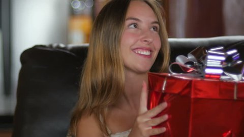 An adorable young woman receives a gift and smiles and says thank you