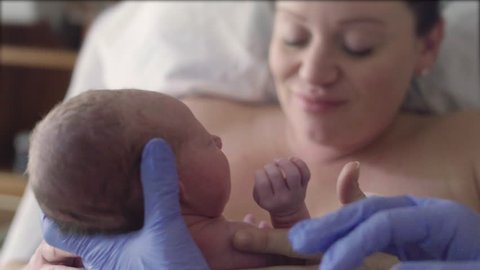 Nurse Hands Newborn Baby to Mother After Birth in Hospital Delivery Room