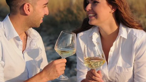Happy couple drinking wine on the beach, selective focus